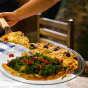 Delicious pizza served at a cozy dinner table with a refreshing drink on the side.